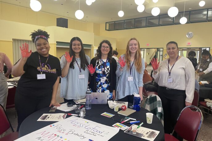 Small group with colored red hands during advocacy workshop