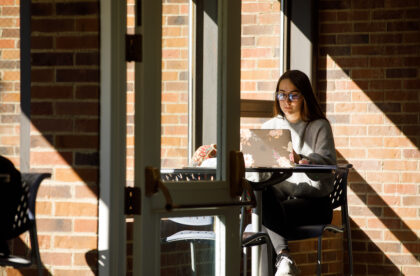 A student studying in the library at Albion College.